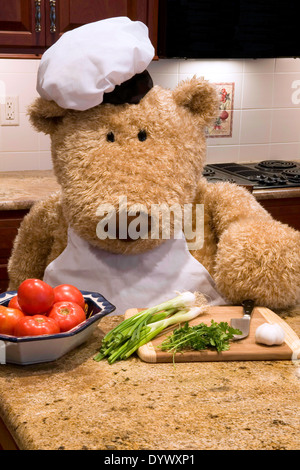 Oversized orsacchiotto di peluche vestito di chef's grembiule e cappello in cucina. Foto Stock