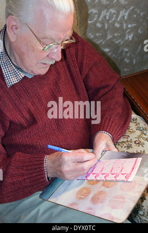 Il vecchio uomo giocando la lotteria Euromillions. Foto Stock
