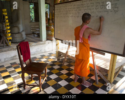 Giovane monaco buddista la scrittura sulla scheda di bianco in un'aula a Angkor Wat, Siem Reap, Cambogia Foto Stock