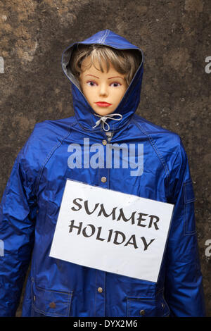 Il manichino "Dred for a Summer Holiday Weather" con un impermeabile blu alla sfilata del Wray Scarecrow Festival fondata nel 1995. La stravagante anche si svolge ogni anno, con un tema diverso nella settimana che conduce fino al giorno di maggio. Quest'anno gli abitanti del villaggio hanno messo gli spaventapasseri 'Hero's & Villains' fuori dalle loro case. Foto Stock