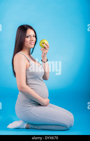 Donna incinta con Apple Foto Stock