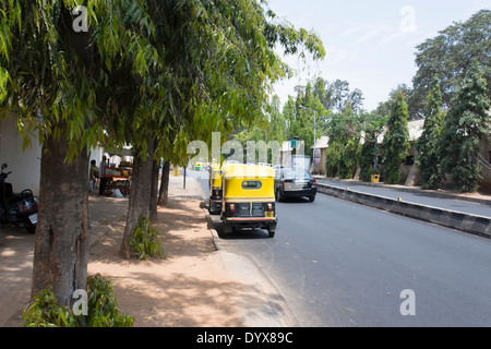 Una scena di strada mostra risciò motorizzati con i loro piloti in appoggio a Bangalore, Karnatake, India Foto Stock