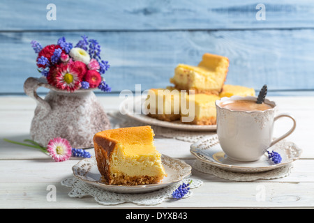 Tazza di caffè, cheesecake e fiori di primavera Foto Stock