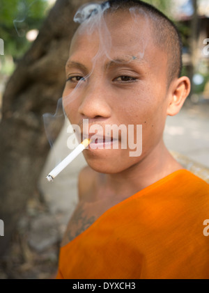 Giovane monaco buddista di Sigaretta fumare al Wat Athvea tempio, Siem Reap, Cambogia Foto Stock