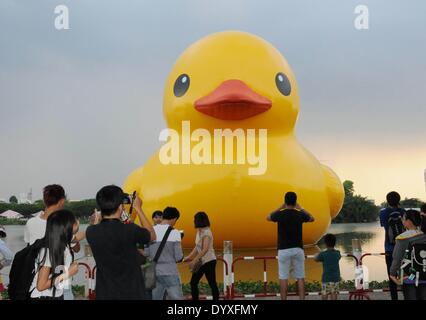 (140427) -- HO CHI MINH CITY, 27 aprile (Xinhua) -- la gente a prendere le foto del gigante rubber duck nel Phu My Hung area residenziale di Ho Chi Minh (HCM) City, Vietnam, 26 aprile 2014. Una 18-metro-tall rubber duck, che ha affascinato la gente in tutto il mondo, saranno visualizzate in Crescent Lake nel Phu My Hung area residenziale di HCM city dal 27 aprile al 31 maggio, i media locali hanno riferito sabato. Progettato da artista olandese Florentijn Hofman, il rubber duck ha iniziato un tour denominato "ampliamento gioie del mondo" nel 2007. HCM City sarà il sedicesimo il luogo in cui è visualizzato. (Xinhua/Tao Jun) d Foto Stock