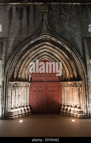 Portale gotico al Carmo chiesa e convento illuminata di notte a Lisbona, Portogallo. Foto Stock