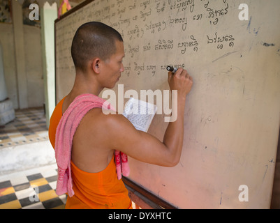 Giovane monaco buddista la scrittura sulla scheda di bianco in un'aula a Angkor Wat, Siem Reap, Cambogia Foto Stock