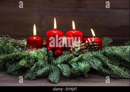 Festive avvento con decor di rosso quattro candele accese, baubles e albero di natale rami. vacanze sfondo. selective foc Foto Stock