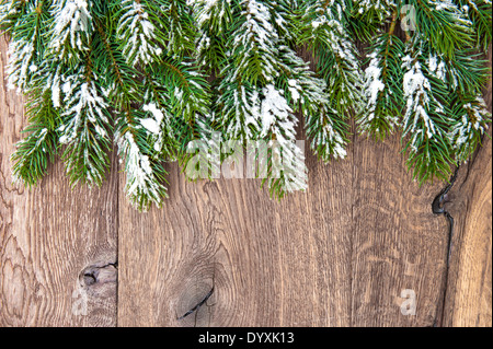 Albero di natale rami su sfondo di legno. bordo verde da non decorato evergreen ramoscelli su sfondo rustick Foto Stock