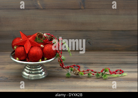 In stile vintage decorazione di Natale con red baubles oltre rustico sfondo di legno Foto Stock