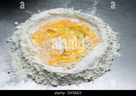 Per fare i tortellini pasta mescolando farina e uova Foto Stock