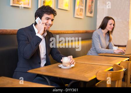 Maschio allegro ristorante cafe smartphone laptop femmina Foto Stock