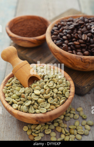 Il verde e il caffè torrefatto in grani nella ciotola di legno closeup Foto Stock