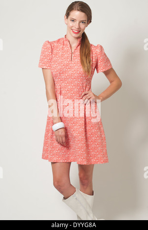 Una bionda capelli donna in coda di cavallo,Caucasian modello femminile che indossa un mod 60s abito rosso, 60s di moda vintage ritratto. Foto Stock