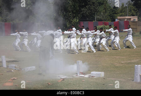 Lahore, Pakistan. 28 apr 2014. Pakistano (Punjab) Police commandos visualizzare le loro competenze durante un passaggio fuori parade, dopo il completamento della loro tre mesi di formazione presso la sede centrale di Ranger di Lahore il 28 aprile 2014. 165 personale di polizia completato la loro formazione commando il lunedì per la lotta contro il terrorismo in Pakistan Ranger (Punjab) sede di Lahore, secondo un comunicato stampa. Credito: Rana Sajid Hussain/Pacific Press/Alamy Live News Foto Stock