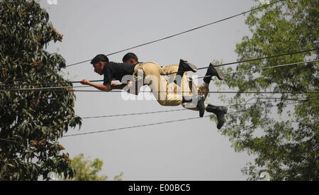Lahore, Pakistan. 28 apr 2014. Pakistano (Punjab) Police commandos visualizzare le loro competenze durante un passaggio fuori parade, dopo il completamento della loro tre mesi di formazione presso la sede centrale di Ranger di Lahore il 28 aprile 2014. 165 personale di polizia completato la loro formazione commando il lunedì per la lotta contro il terrorismo in Pakistan Ranger (Punjab) sede di Lahore, secondo un comunicato stampa. Credito: Rana Sajid Hussain/Pacific Press/Alamy Live News Foto Stock