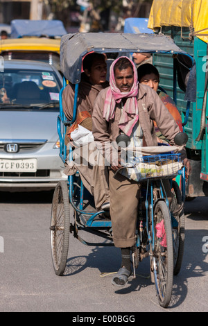 New Delhi, India. In rickshaw con il conducente e i passeggeri nel centro di Delhi. Foto Stock