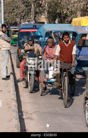 New Delhi, India. In rickshaw conducente e passeggero a metà giornata il traffico di Delhi. Foto Stock