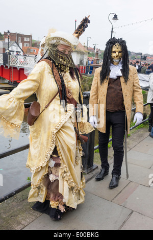 Un uomo mascherato e il suo partner di donna in stile gotico georgiano abito a Whitby Goth Week End primavera 2014 Foto Stock