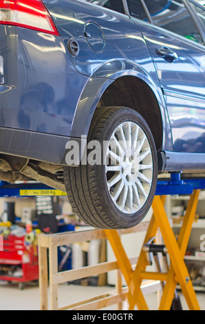 Auto sul ponte in garage preparato per la riparazione. Foto Stock