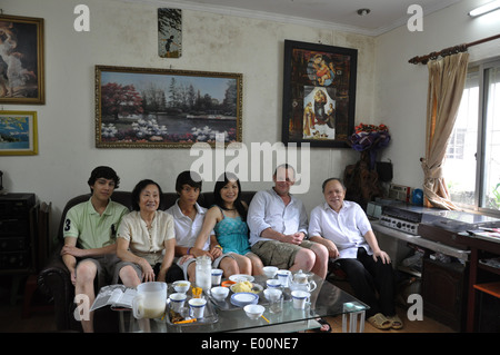 Anziana coppia vietnamita con il loro nipote e suo marito britannico e due razza mista figli posano per una foto di Hanoi, Vietnam Foto Stock