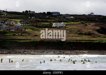 Surfers di imparare a navigare a Porthmeor Beach di St Ives in Cornovaglia Foto Stock