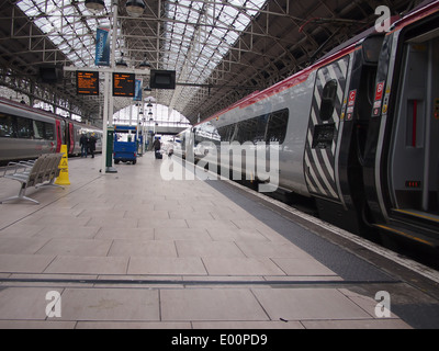 Una piattaforma presso la stazione ferroviaria di Piccadilly a Manchester con una vergine Pendolino in piedi presso di essa. Foto Stock