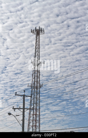 Elettrico di torri e pali con fili per la comunicazione e l'elettricità luogo fortemente contro uno sfondo di un cielo nuvoloso Foto Stock