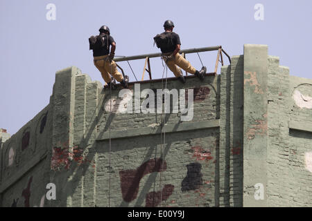 Lahore. 28 apr 2014. La polizia commandos visualizzare le loro competenze durante un passaggio fuori parade, dopo il completamento della loro tre mesi di formazione presso il Pakistan Ranger (Punjab) Sede in Pakistan orientale di Lahore il 28 aprile 2014. Circa 165 poliziotti hanno completato la loro formazione commando il lunedì per la lotta contro il terrorismo in Pakistan Ranger (Punjab) Sede a Lahore. Credito: Jamil Ahmed/Xinhua/Alamy Live News Foto Stock