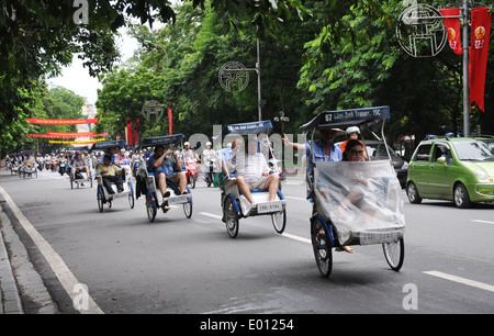 Turisti viaggiano in cyclo ad Hanoi, capitale del Vietnam Foto Stock