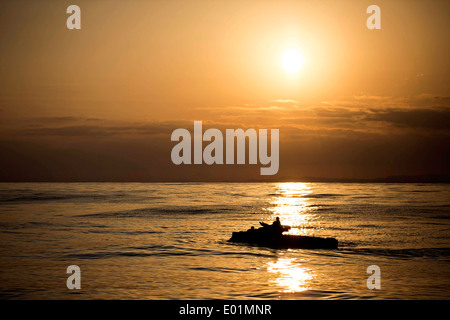 Un US Marine Corps Amphibious Assault manovre del veicolo attraverso l'acqua al tramonto durante una splash ed esercizio di recupero Febbraio 28, 2014 nel Mar Cinese Orientale. Foto Stock