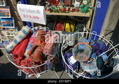 Di lana e cashmere blend tartan sciarpe e cappelli sul display nella parte anteriore di un negozio turistico sul Royal Mile di Edimburgo. Foto Stock