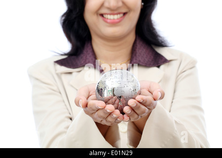 Giovani indiani business donna azienda globo puzzle contro white Foto Stock