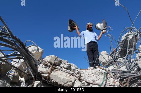 Nablus, Territorio palestinese. 29 apr 2014. Un uomo palestinese contiene altoparlanti danneggiati appartenenti ad una moschea dopo che esse sono state demolite dai bulldozer israeliano in Khirbet Al-Taweel villaggio vicino alla Cisgiordania città di Nablus, 29 aprile 2014. Le forze israeliane hanno demolito numerose strutture, tra cui una moschea, in un villaggio palestinese di martedì. Credito: Ayman Nobani/Xinhua/Alamy Live News Foto Stock