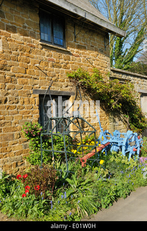Trascinare Harrow & Potato Harvester contro Ironstone parete Cottage Foto Stock