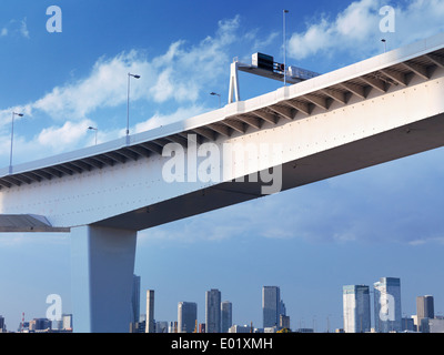 Autostrada sopraelevata oltre il cielo blu con il Tokyo City line in background. Tokyo, Giappone. Foto Stock