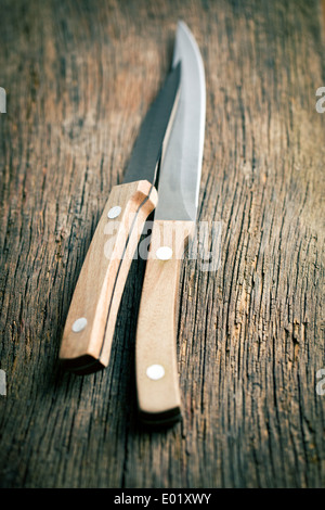 Set di coltelli da cucina sul vecchio tavolo in legno Foto Stock