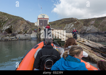 Una barca turistica cravatte-fino alla stazione di RNLI presso il St Giustiniano vicino a St Davids, Pembrokeshire, Wales, Regno Unito Foto Stock