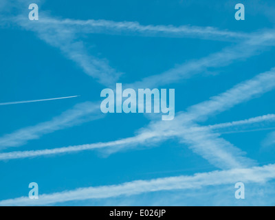 Configurazione di molte contrails/vapori delle scie di aerei nel cielo blu. Foto Stock
