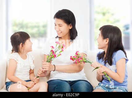 Due figlie di consegnare i garofani madre Foto Stock