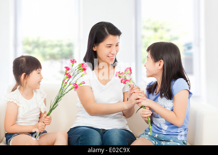 Due figlie di consegnare i garofani madre Foto Stock