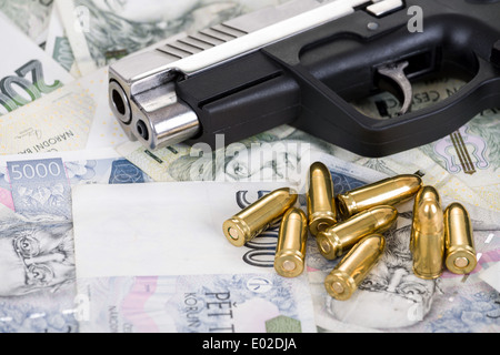 Dettaglio della pistola a proiettile su ceca sfondo banconote Foto Stock