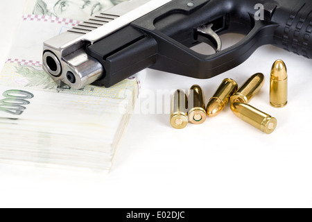 Pistola con bullet e il ceco banconote isolati su sfondo bianco Foto Stock