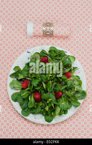 La valeriana con fragole e petali di fiori servita su un piatto e igienico Foto Stock