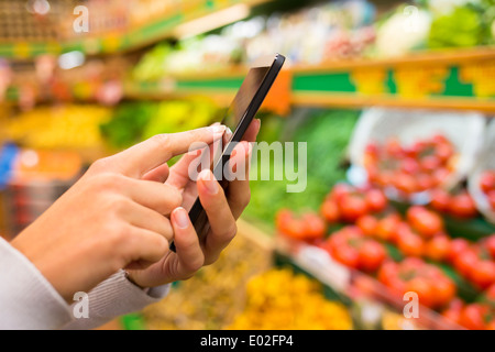 Vicino femmina telefoni cellulari negozio a mano Foto Stock