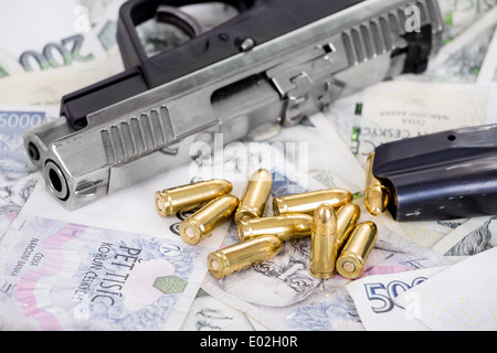 Dettaglio della pistola a proiettile su ceca sfondo banconote Foto Stock