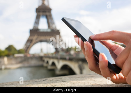 Close-up femmina a mano mobile phone Paris Seine ponte sms messaggi e-mail Foto Stock