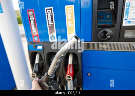 Uomo con ugello di rifornimento di olio di gas e diesel ad alta velocità per i biocarburanti pompe diesel in corrispondenza di una stazione di benzina Irlanda del Nord Foto Stock