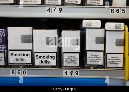 Marche di sigarette in pianura il confezionamento con le avvertenze sanitarie in armadio in un piccolo negozio Irlanda del Nord Foto Stock