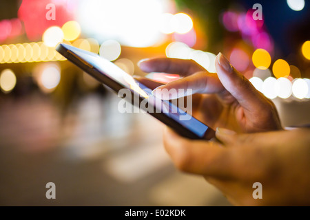 Femmina telefono cellulare close-up all'aperto a mano del messaggio sms e-mail Foto Stock